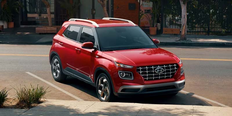2025 Hyundai Venue parked on city street in red