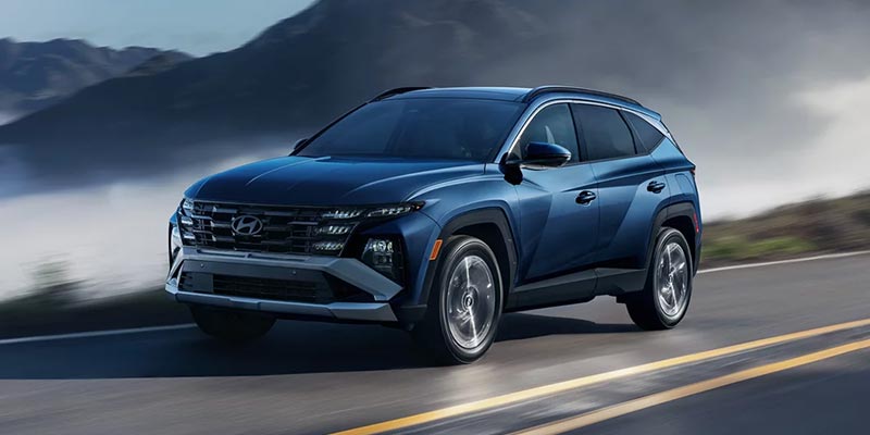 Blue Hyundai SUV driving mountain road
