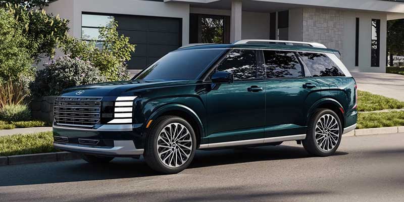 Green Hyundai Palisade SUV parked outside a modern home.